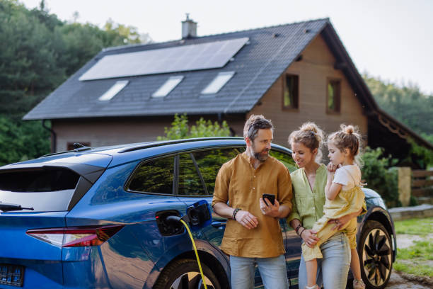 famille devant voiture branchée, maison avec panneaux solaires en fond - solest energies - alsace