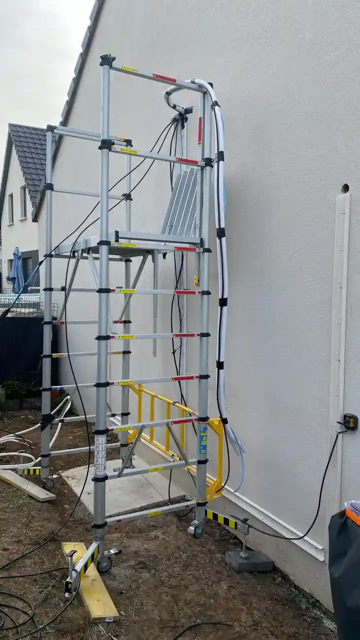 Travaux extérieurs sur échafaudage lors de l'installation d'une climatisation réversible sur une maison Phénix à Oberhergheim